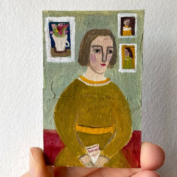 Image of woman with paintings (book in hand)