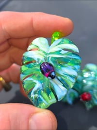 Image 1 of Uv reactive Variegated monstera leaf pendant with purple ladybug 