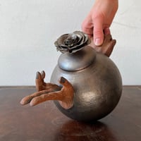 Image 1 of a golden handheld teapot