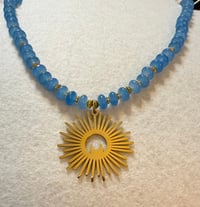 Image 1 of Chalcedony with gold tone spacers and gold tone sun/moon pendant.