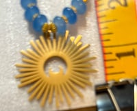 Image 3 of Chalcedony with gold tone spacers and gold tone sun/moon pendant.