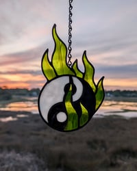 Image 1 of yin yang in green flames