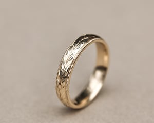 Image of 9ct yellow gold 4mm ‘Olive leaf’ and milled edge engraved ring