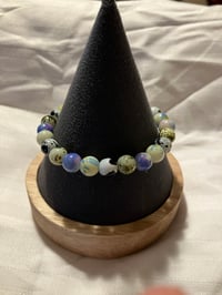 Image 1 of 8mm Paint splattered glass bead stretch bracelet with shell charm