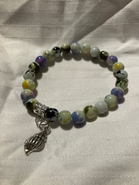 Image 2 of 8mm Paint splattered glass bead stretch bracelet with shell charm