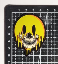 Image 2 of Glow In The Dark Melting Smiley Face Skull Matte Vinyl Sticker 