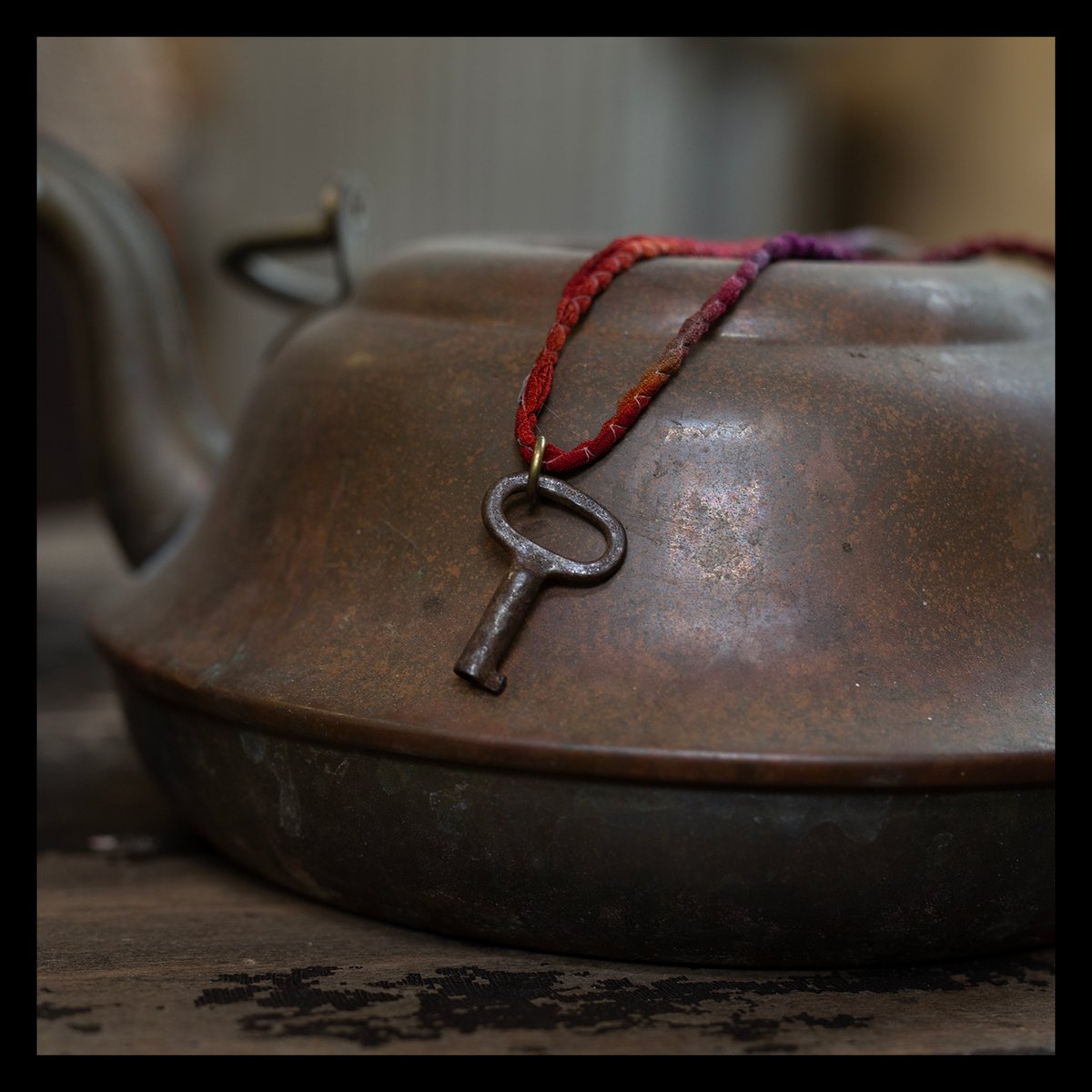 Tiny oval barrel key on silk "Sunset" cord