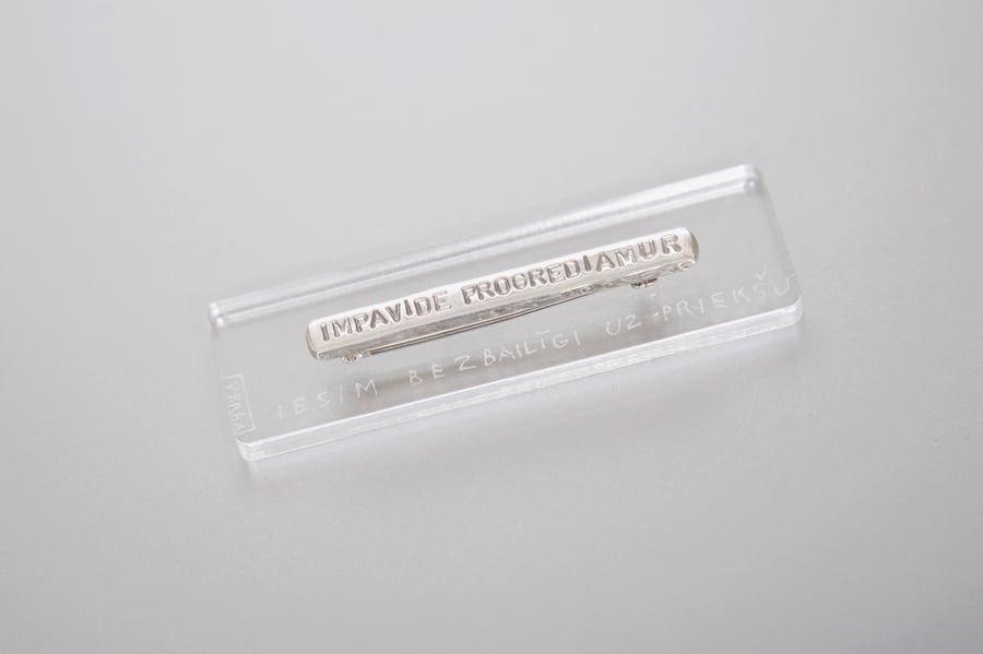 Image of silver brooch with inscription in Latin