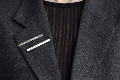 Image of silver brooch with inscription in Latin