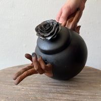 Image 1 of a handheld teapot