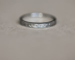 Image of Platinum 2mm flat court ‘Olive leaf’ and milled edge engraved ring