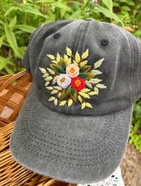 Image 2 of Light blue, pink, and red hand embroidered flowers on an adjustable dark grey hat