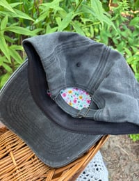 Image 3 of Light blue, pink, and red hand embroidered flowers on an adjustable dark grey hat