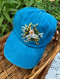Image 2 of Blue and pink hand embroidered flowers on an adjustable blue hat