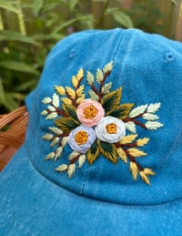 Image 1 of Blue and pink hand embroidered flowers on an adjustable blue hat