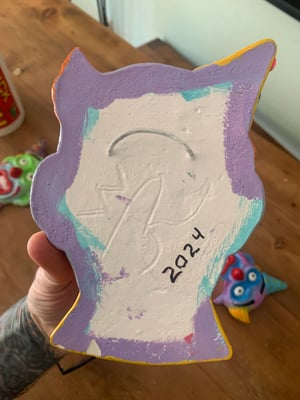 Green eye clown yellow hat. 