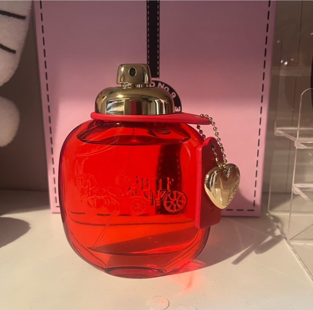 Image of Coach Love-Elegant red glass bottle. Gold cap with heart charm. Perfect for gifting. This beautiful 