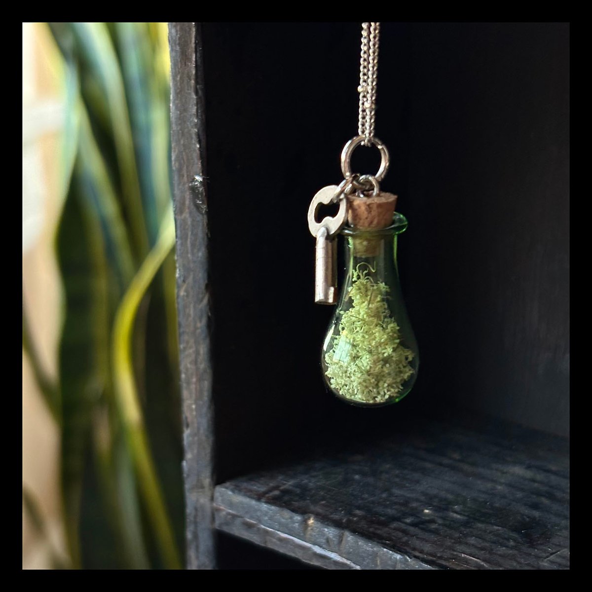 Green vial of Queen Anne's lace with tiny key 