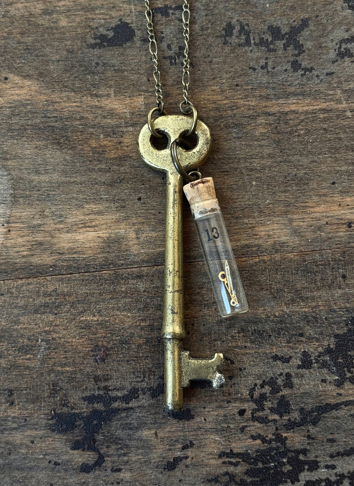Large brass key with vintage clock parts in vial