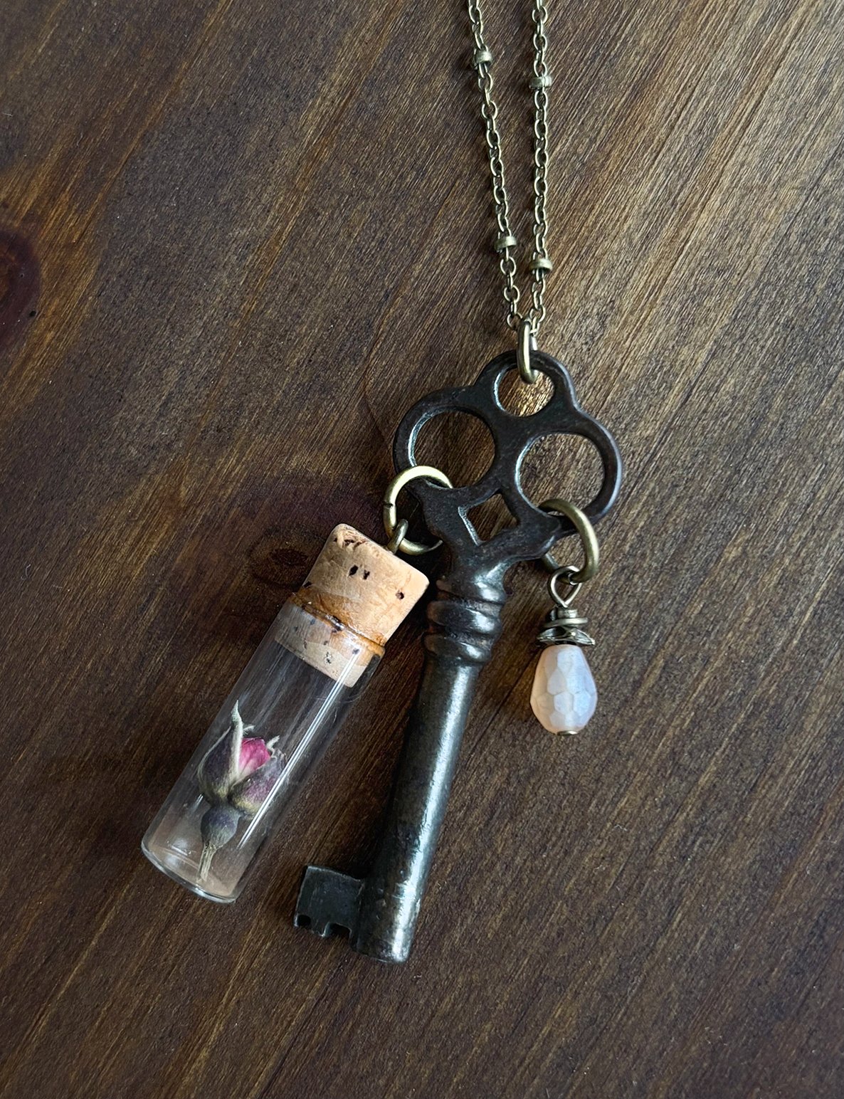 Skeleton key with bead & vintage clock parts vial with dried rosebud
