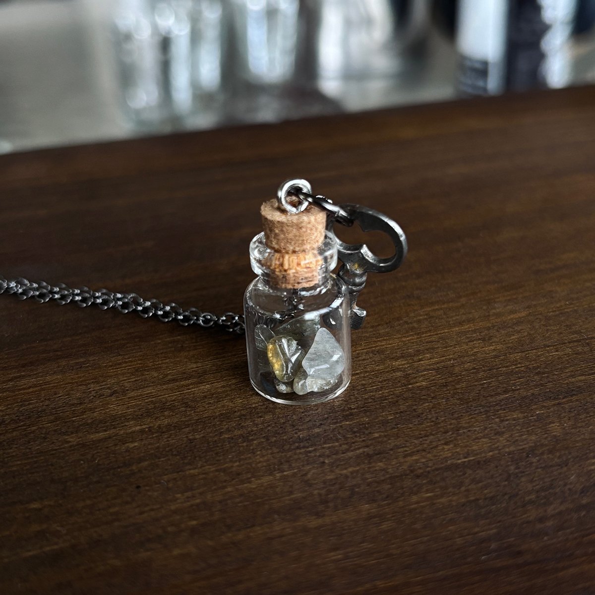 Tiny key with labradorite crystals in glass vial