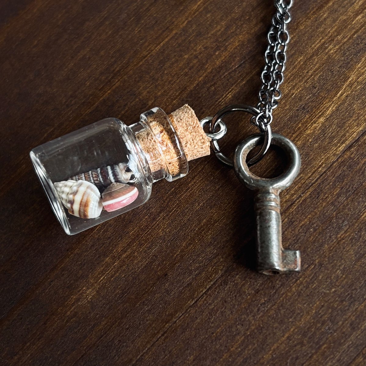 Small round key with vial of tiny seashells