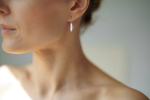 Image of light plain silver earrings with inscription in Latin