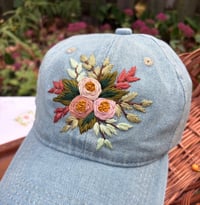 Image 1 of Pink hand embroidered flowers on an adjustable light blue jean hat