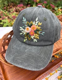 Image 5 of Dark, medium and light pink hand embroidered flowers on an adjustable dark green fabric hat