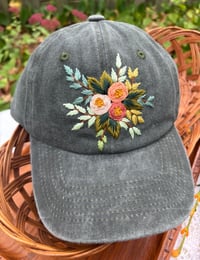 Image 4 of Dark, medium and light pink hand embroidered flowers on an adjustable dark green fabric hat