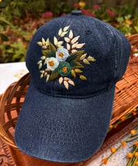 Image 1 of Blue and turquois hand embroidered flowers on an adjustable dark blue jean fabric hat
