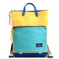 Mochila Book Holder Iconic Impermeable amarilla con bolsillo azul.