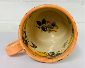 Image of Peach coloured figurative cylinder mug
