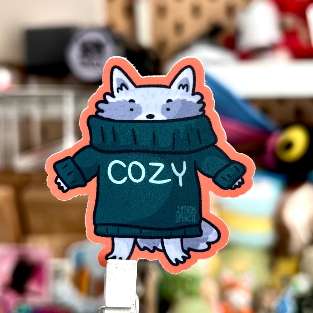 Image of Raccoon in a cozy sweater mini vinyl sticker