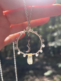 Image 1 of labradorite circular wire wrapped necklace with crescent moon and garnet in center