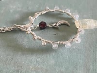 Image 4 of labradorite circular wire wrapped necklace with crescent moon and garnet in center