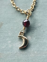 Image 2 of gold crescent moon necklace with red garnet