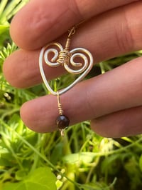 Image 7 of wire wrapped heart with tiny garnet in gold