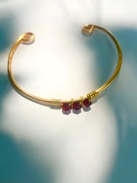 Image 2 of dark red garnet bangle in gold
