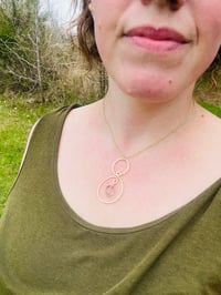 Image 6 of gold hammered spiral necklace with tiny purple fluorite stone