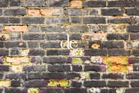 Decaying worn black brick wall. Digital background Download