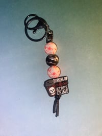 “Running on caffeine and true crime” keychain