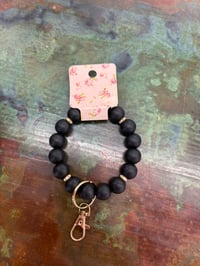 Image 1 of black wristlet keychain with gold accents