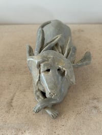 Image 1 of Winged Creatures: Green dog at rest