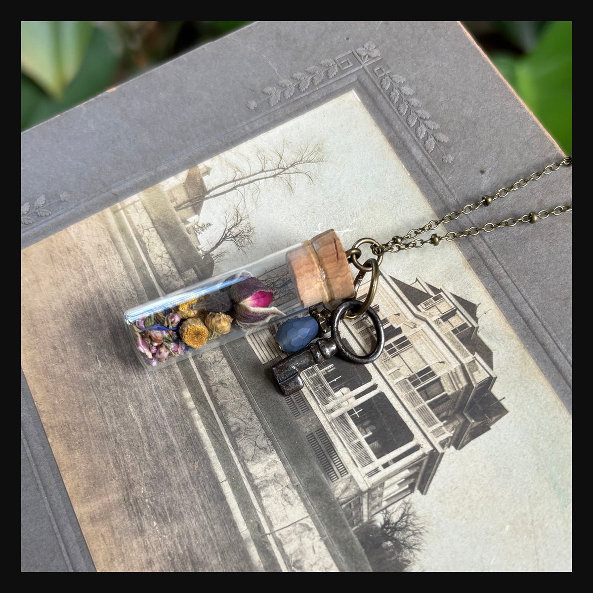 Dried Floral in vintage watch parts vial with barrel key necklace