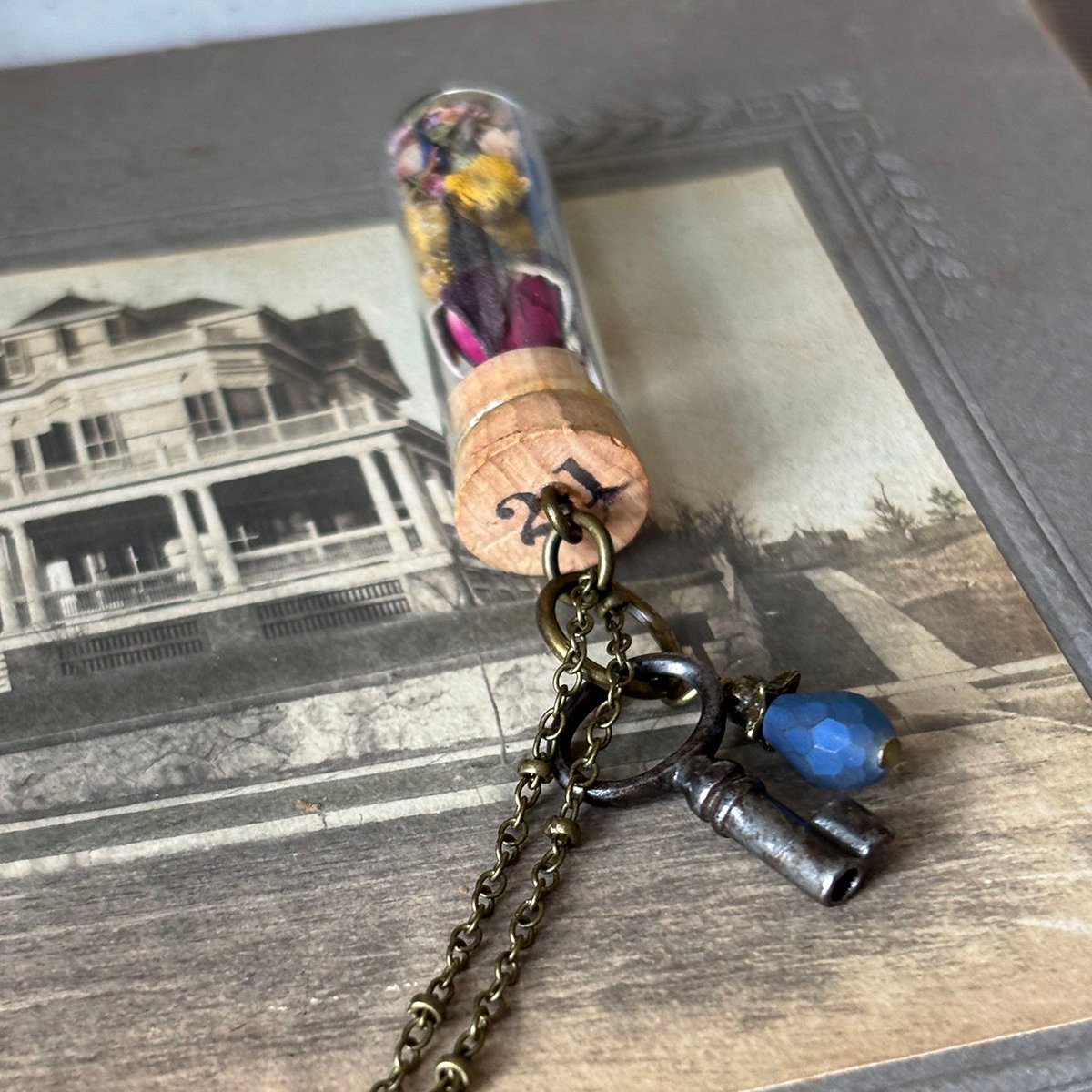 Dried Floral in vintage watch parts vial with barrel key necklace