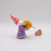 Image 3 of Stewart the gnome with orange flowers and Sage the brown spaniel puppy