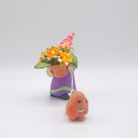 Image 4 of Stewart the gnome with orange flowers and Sage the brown spaniel puppy