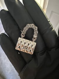 C.c. Silver metal bag flat back charm.