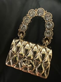 C..c. Gold metal bag flat back charm.